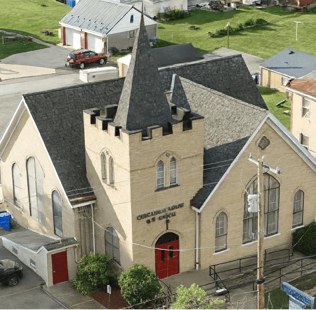 Historical aerial view of Circles of Love Church showing the beautiful stone architecture and community setting